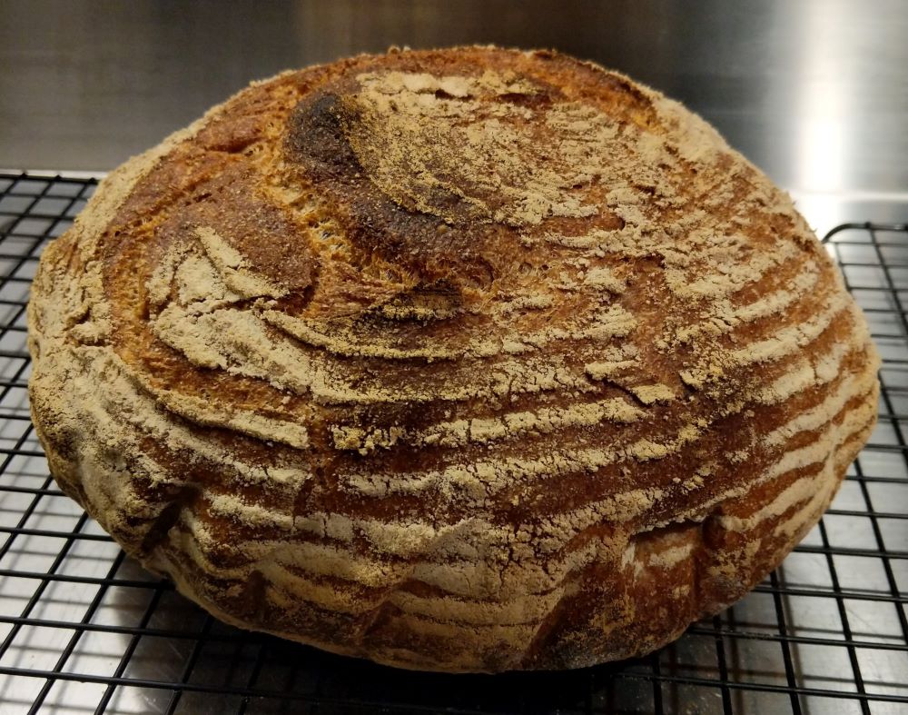 A round loaf of bread marked with horizontal strips of flour